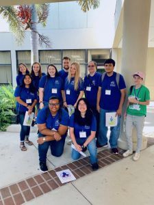 Diverse group of students wearing blue PSC Student Government Association shirts outdoors.