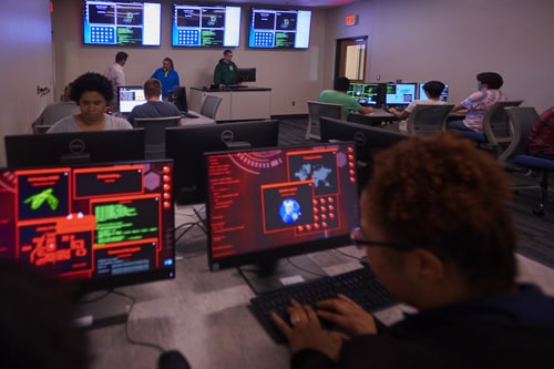 Cybersecurity students engaged in hands-on cyber defense exercises at Pensacola State College.