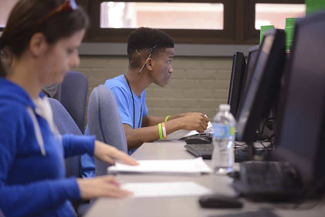 Students engaged in computer programming and analysis coursework at Pensacola State College.