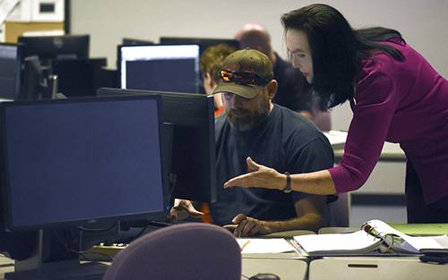Computer Information Systems student working with instructor in a computer lab.