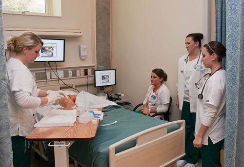 Critical care nursing training with students practicing patient care techniques.