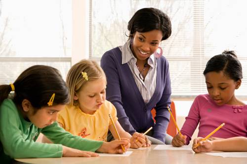 Engaged teacher with young children in a preschool learning activity.