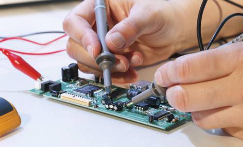 High-tech electronics engineering technology student working on circuit board.