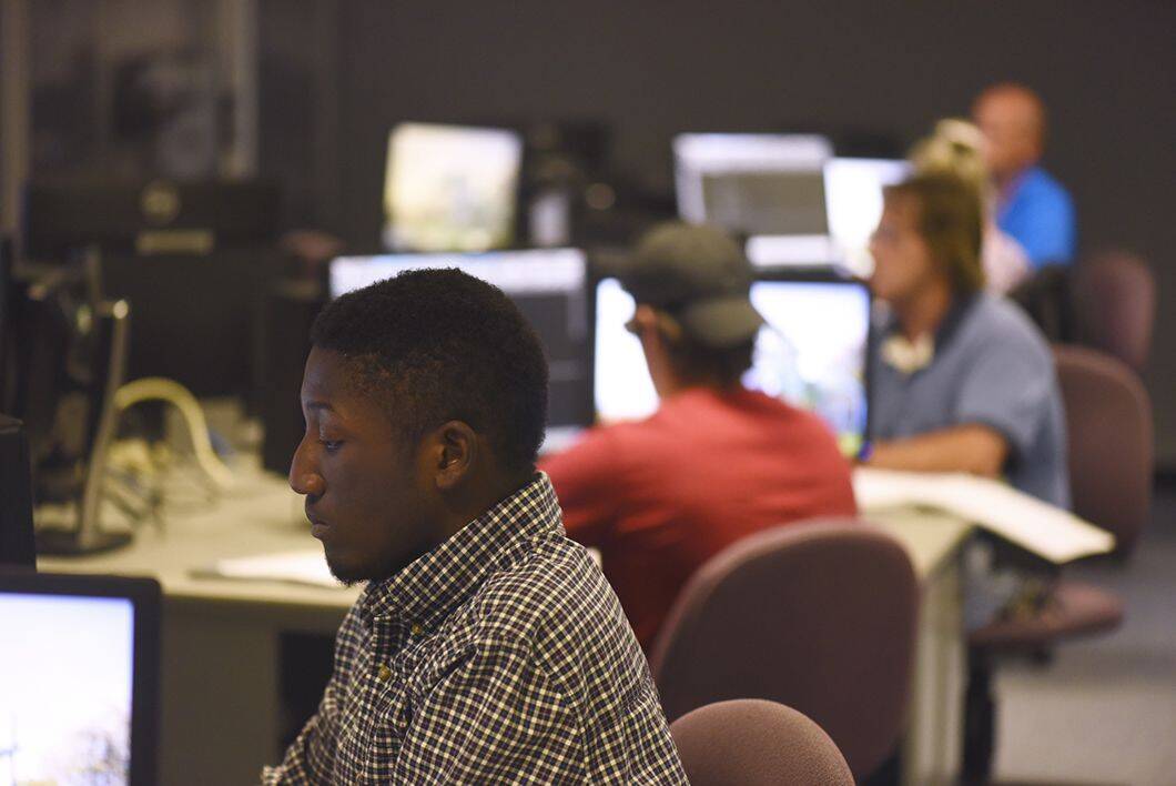 Accessible computer science classroom with diverse students working on coding projects at Pensacola.