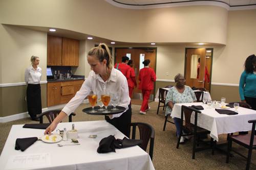 Event Planning Management training session in a restaurant setting with students practicing service.
