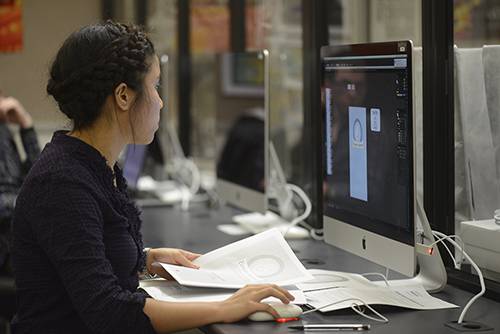 Student working on computer for business and management studies at Pensacola State College.