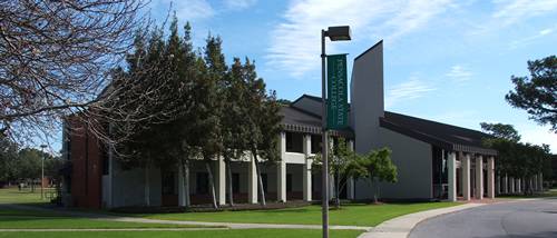 Modern college campus building with trees and clear sky, showcasing campus map and navigation featur.