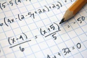 Mathematics concepts and equations on graph paper with pencil for higher education.