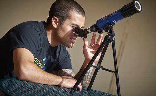 Physics student using a telescope for astronomy and scientific research at Pensacola State College.