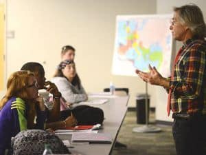 Diverse students engaged in social sciences lecture with instructor, classroom setting, educational.