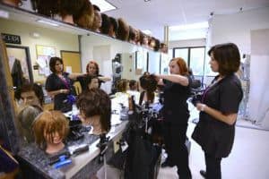 Highly skilled cosmetology students practicing hair styling techniques in a classroom setting.