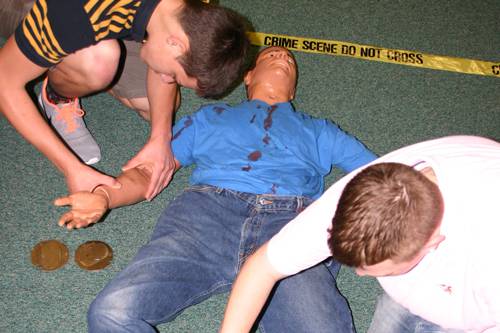 Crime scene investigation training with mock victim and forensic markers.