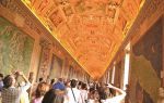 Historic art gallery with visitors exploring ornate ceiling murals.