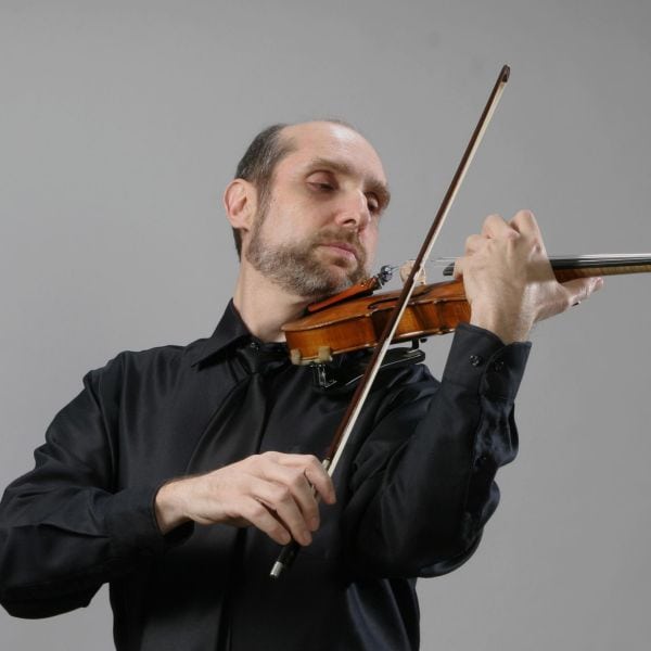 Violinist playing at Pensacola State College free concert, highlighting music program.