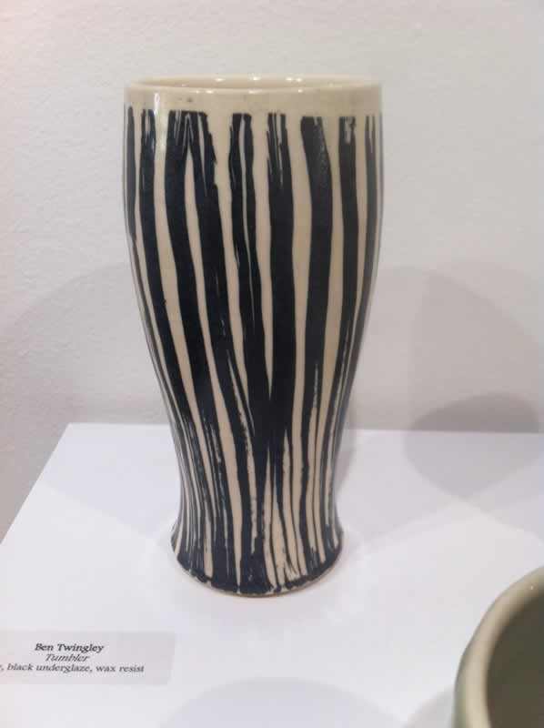 Ceramic vase with black and white vertical stripes, part of the PSC Art Faculty Exhibit at Switzer G.