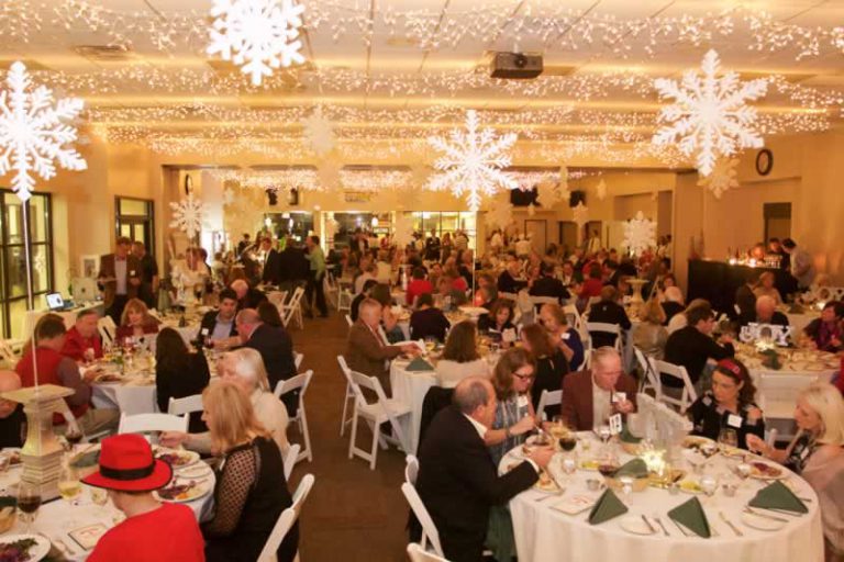 Festive holiday event with students and community members celebrating together.