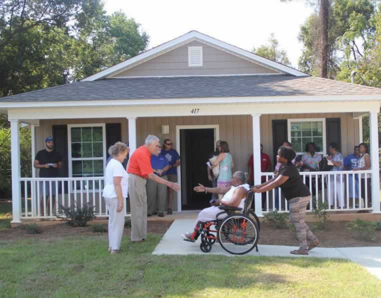 Accessible, keyword-rich image of Habitat for Humanity home dedication honoring Pensacola State empl.
