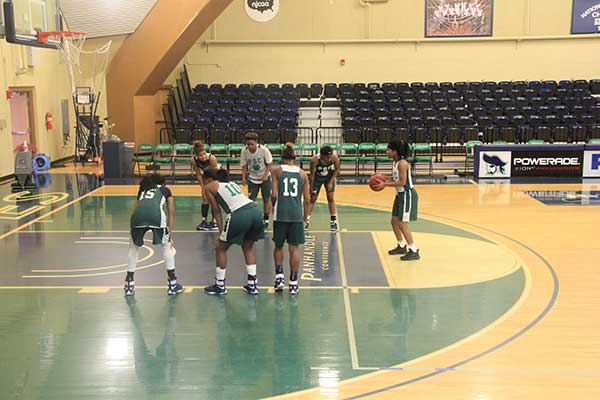 Lady Pirates basketball team practicing free throws in an indoor gymnasium.