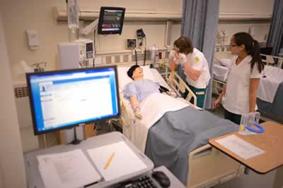 Nursing simulation lab at Pensacola State College with students and instructor.