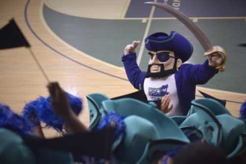 PSC Pirates mascot at basketball scrimmage, promoting college sports events and schedules.