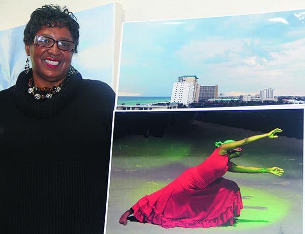 Diverse woman veteran displays artwork at Pensacola State College exhibit.