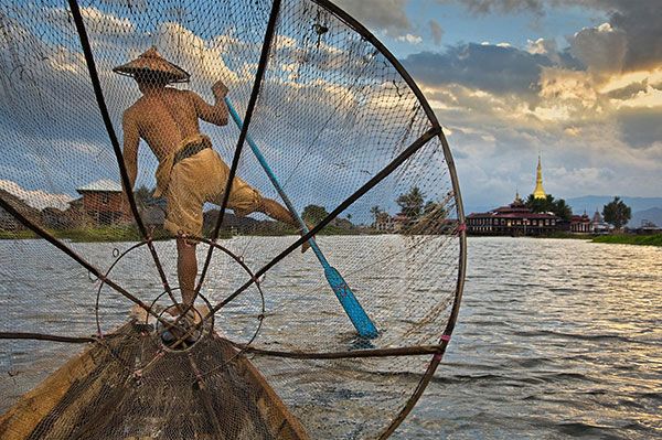 Traditional fishing techniques on the Pensacola waterfront at sunset.