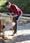 Lumberjack student using a saw to cut wood outdoors at Pensacola State College.