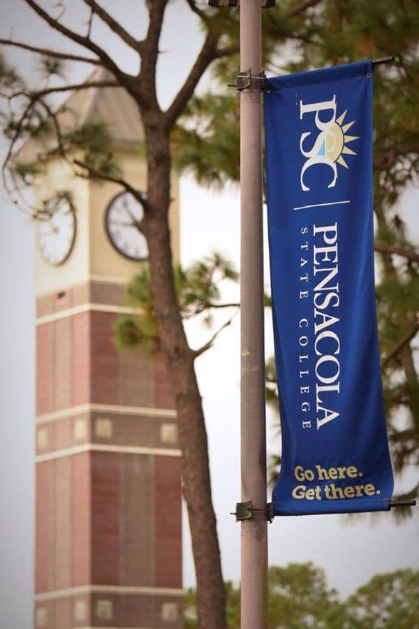 Blue Pensacola State College banner on campus with college logo and slogan.