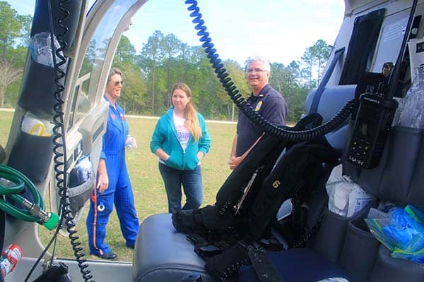 Emergency medical training session with students and instructors outdoors.