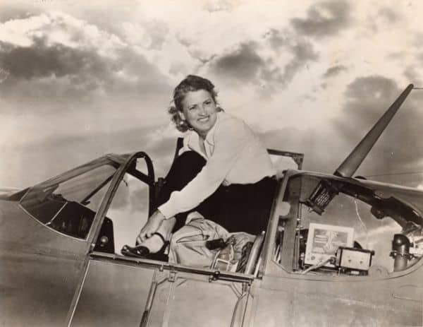 Historic black-and-white photo of Jackie Cochran in an aircraft cockpit, highlighting her aviation l.