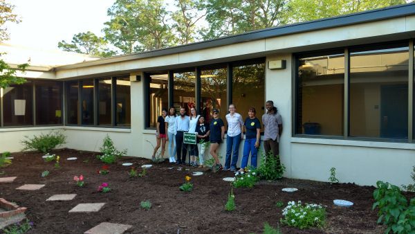 Group of students and faculty standing in front of Phi Theta Kappa Friendly Garden at Pensacola Stat.