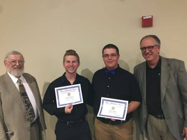Two students receiving Cantonment Rotary Club scholarships with mentors at an award ceremony.
