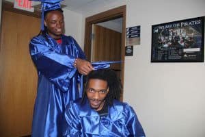 High school graduates in blue caps and gowns celebrating academic achievement.