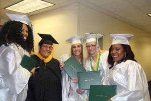 Diverse group of graduates in caps and gowns celebrating academic achievement.
