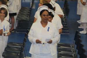 Nursing students in white uniforms at graduation ceremony, showcasing achievement and career readine.