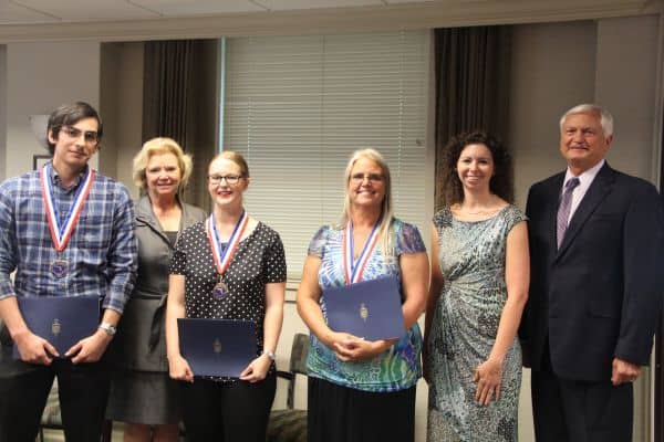 Group of Pensacola State students and officials celebrating academic achievement at awards event.