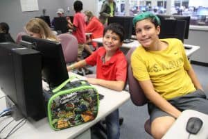 Children engaging in educational activities at a technology-focused summer program.