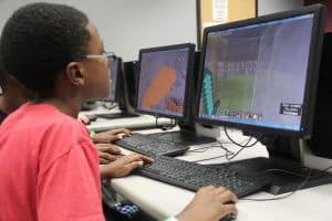 Young students engaged in coding activities at Kids&rsquo; College 2017, learning programming skills on de.