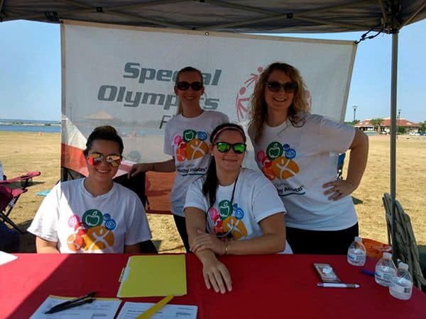 Accessible sports event with participants wearing themed T-shirts at Pensacola Beach.