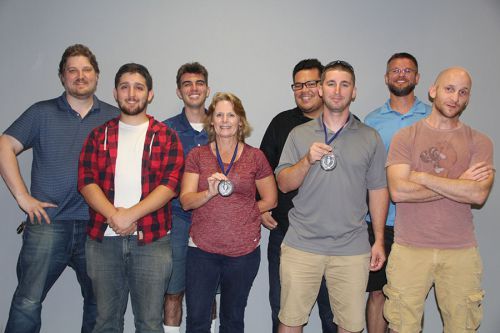Students proudly display medals after completing a program at Pensacola State College.