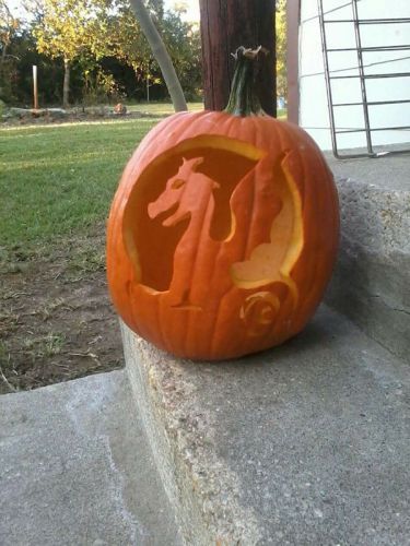 Pumpkin with intricate dragon carving for Halloween celebration at Pensacola State College.