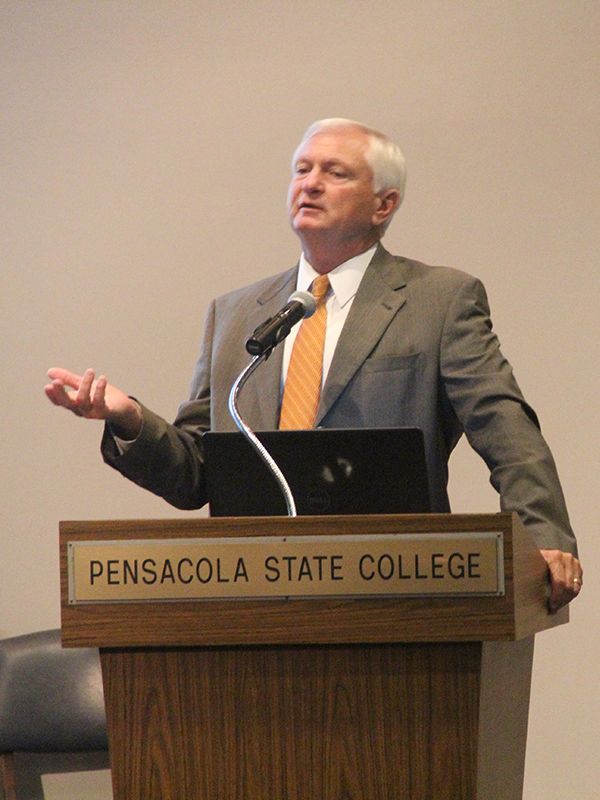 Senior male speaker delivering a presentation at Pensacola State College event.