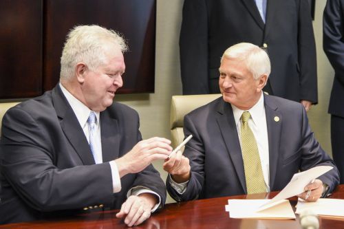 Senior men in business suits exchanging information during a professional discussion.