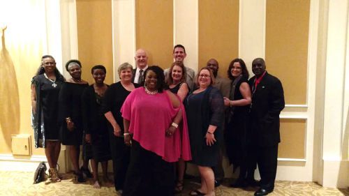 Group of diverse students and faculty celebrating at Pensacola State College event.
