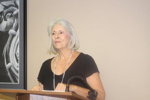 Senior woman speaking at a college event, emphasizing lifelong learning and higher education opportu.
