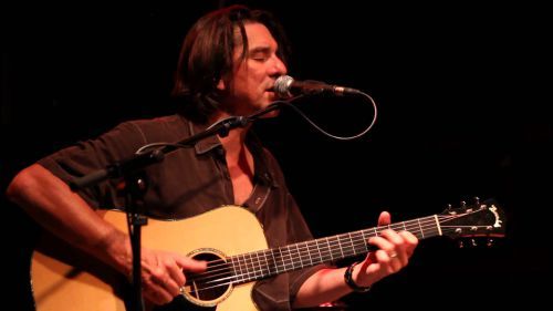 Guitarist Mike Cooley playing acoustic guitar during a solo concert at Pensacola State College.
