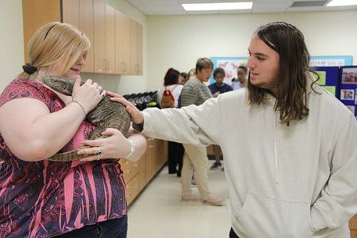 Student interacts with a small animal during Vet Tech Open House event at Pensacola State College.