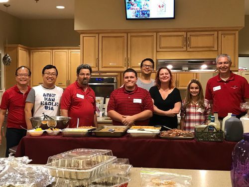 Community event with diverse group of people in a kitchen setting, celebrating together.