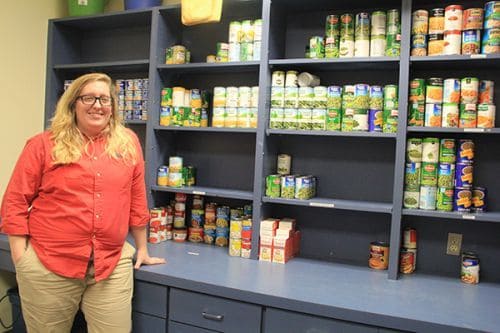 Food pantry volunteer at Pensacola State College supporting students with essential food supplies.