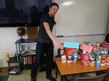 Students from the Adult Education Program donate food items to PSC Food Pantry for community assista.
